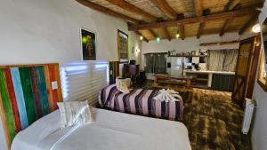a hotel room with two beds and a kitchen at La Posada del Rio in Tilcara