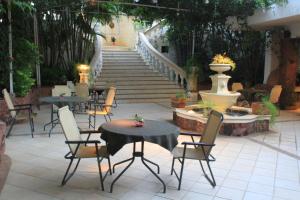 a patio with tables and chairs and a staircase at Premier Hill Suites Hotel in Asuncion
