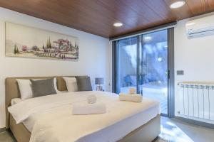 a bedroom with a large bed and a large window at Stunning 4 Bedroom Duplex in Kfardebian