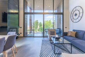 a living room with a couch and a clock on the wall at Stunning 4 Bedroom Duplex in Kfardebian