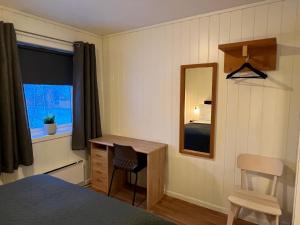 a bedroom with a desk and a mirror and a bed at Tanabrew in Tana