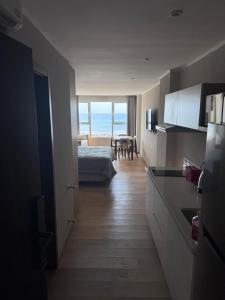 a room with a bed and a kitchen with a table at MONOAMBIENTE EDIFICIO OCEANO NECOCHEA frente al mar, in Necochea