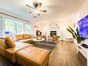 a living room with a couch and a tv at HotTub|Sauna|Theater|BBQ|Firepit|Game|Pool in Long Pond