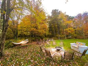 a group of chairs and a fire pit in a yard at HotTub|Sauna|Theater|BBQ|Firepit|Game|Pool in Long Pond