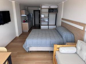 a small bedroom with a bed and a couch at MONOAMBIENTE EDIFICIO OCEANO NECOCHEA frente al mar, in Necochea +13 photos