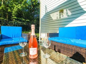 a bottle of wine sitting on a table with two wine glasses at HotTub|Sauna|Theater|BBQ|Firepit|Game|Pool in Long Pond