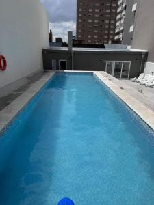 a large blue swimming pool on the roof of a building at MONOAMBIENTE EDIFICIO OCEANO NECOCHEA frente al mar, in Necochea