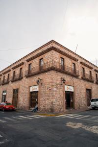a brick building with a car parked in front of it at Downtown Suite Wifi in Morelia