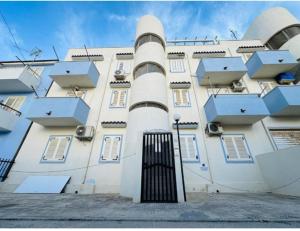 a white building with a gate in front of it at Casa vacanza "Orchidea" in Marzamemi