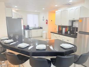 a kitchen with a table and chairs with wine glasses at Las Palmas 4BR 4BA Penthouse OV 701 in Campo del Medio