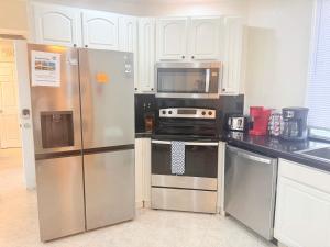 a kitchen with stainless steel appliances and white cabinets at Las Palmas 4BR 4BA Penthouse OV 701 in Campo del Medio