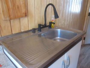 a kitchen sink with a faucet on top of it at Cabaña Pehuen in San José de Maipo +11 photos