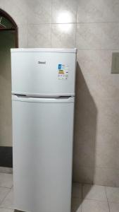 a white refrigerator in a room with a wall at Duque de Caxias Apartmento in Duque de Caxias +2 photos