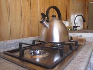 a tea kettle sitting on top of a stove at Cabaña Pehuen in San José de Maipo