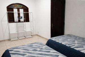 a bedroom with a bed and a window and a shelf at Duque de Caxias Apartmento in Duque de Caxias