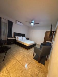 a bedroom with a bed and a chair and a ceiling fan at Habitación Roble, cómoda y espaciosa in Saltillo +3 photos