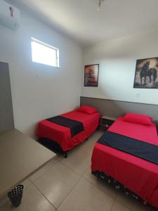 a room with two beds and a window at Quarto Duplo Comercial - Queen's Hotel in Formosa