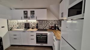 a kitchen with white cabinets and a white refrigerator at La Valiette in La Seyne-sur-Mer