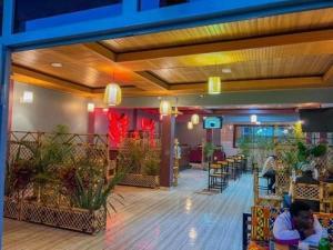 a lobby of a restaurant with people sitting at tables at The gorilla hideout in Ruhengeri