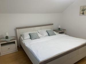 a bedroom with a large white bed with two pillows at Dům na jihu Valtice in Valtice