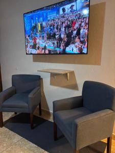 a waiting room with two chairs and a tv on the wall at Habitación Roble, cómoda y espaciosa in Saltillo