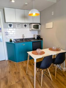 a kitchen with blue cabinets and a table and chairs at Flat Hotel Merc Espaçoso Ibirapuera 4 estrelas com Wi-Fi Recepção 24 horas 3PRI in São Paulo