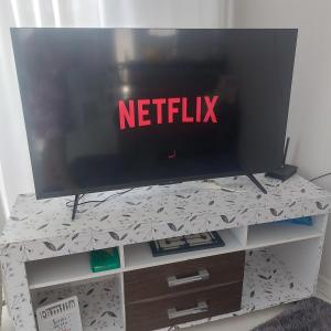 a tv sitting on top of a tv stand at Descanso Paz e sossego com muito aconchego in Prado