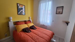 a bedroom with a bed with orange sheets and yellow pillows at La Valiette in La Seyne-sur-Mer