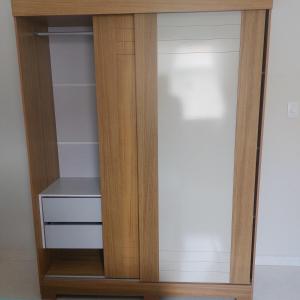 a closet with a wooden door and a shelf at Descanso Paz e sossego com muito aconchego in Prado
