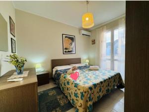 a bedroom with a bed with a teddy bear on it at Casa vacanza "Orchidea" in Marzamemi +11 photos