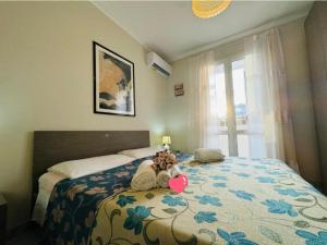 a teddy bear sitting on top of a bed at Casa vacanza "Orchidea" in Marzamemi