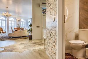 a bathroom with a toilet and a living room at Cidadela do Viriato Deluxe in Viseu