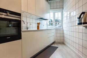 a kitchen with white tiled walls and a window at Cidadela do Viriato Deluxe in Viseu +16 photos