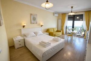 a bedroom with a white bed and a dining room at Solid Residence Apartamente in Mamaia