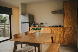 a kitchen with a wooden table and chairs and a kitchen with a refrigerator at Casas VV in Valle de Guadalupe