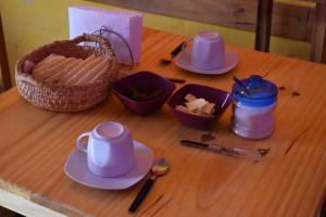 a table with plates and cups and a basket on it at Kamaq Hostel in Humahuaca