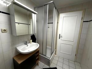a white bathroom with a sink and a shower at Apartment am Ostorfer See in Schwerin