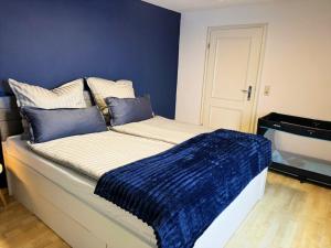 a bedroom with a bed with a blue wall at Apartment am Ostorfer See in Schwerin