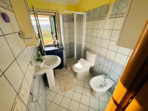 a bathroom with two sinks and a toilet at Casa Orchidea Altera in Marzamemi +12 photos
