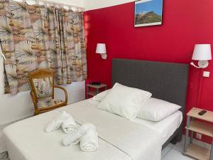ein Hotelzimmer mit zwei Betten, auf denen Handtücher liegen in der Unterkunft Hotel Le Rotabas in Sainte-Anne