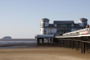 a pier with a building on the beach at Converted Coastal Coach House in Weston-super-Mare