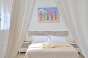 a bedroom with a bed with white curtains and surfboards at Sand & Beach in Pájara
