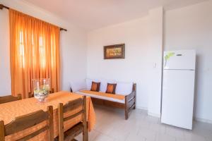 a living room with a table and a refrigerator at Maria Apartments in Amoopi