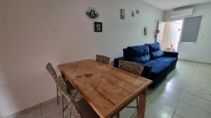 a living room with a wooden table and a blue couch at Casa Holambra Van den Broek in Holambra