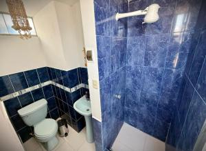 a blue tiled bathroom with a toilet and a sink at Ocean Blue in Huanchaco