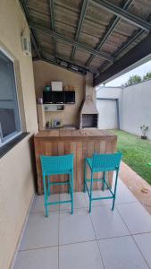 two blue chairs sitting on a patio with a kitchen at Casa Holambra Van den Broek in Holambra