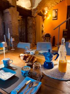 a table with a blue pitcher of orange juice on it at Moulin Lombard B&B Chambre et table d Hôtes Massages & Bien-être in Les Arcs sur Argens