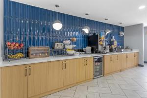 a kitchen with wooden cabinets and a blue wall at Best Western Montrose Inn in Montrose