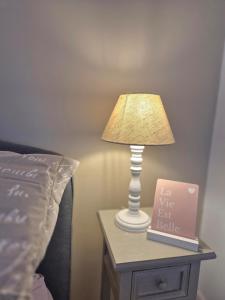 a lamp on a table next to a bed at Centre Chartres Parking privé Climatiseur in Chartres