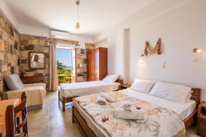 a bedroom with two beds and a table and a chair at Maria Apartments in Amoopi